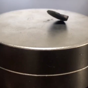 Screenshot aus einem Video, in dem der vermeintliche Supraleiter LK-99 partiell schwebt.  