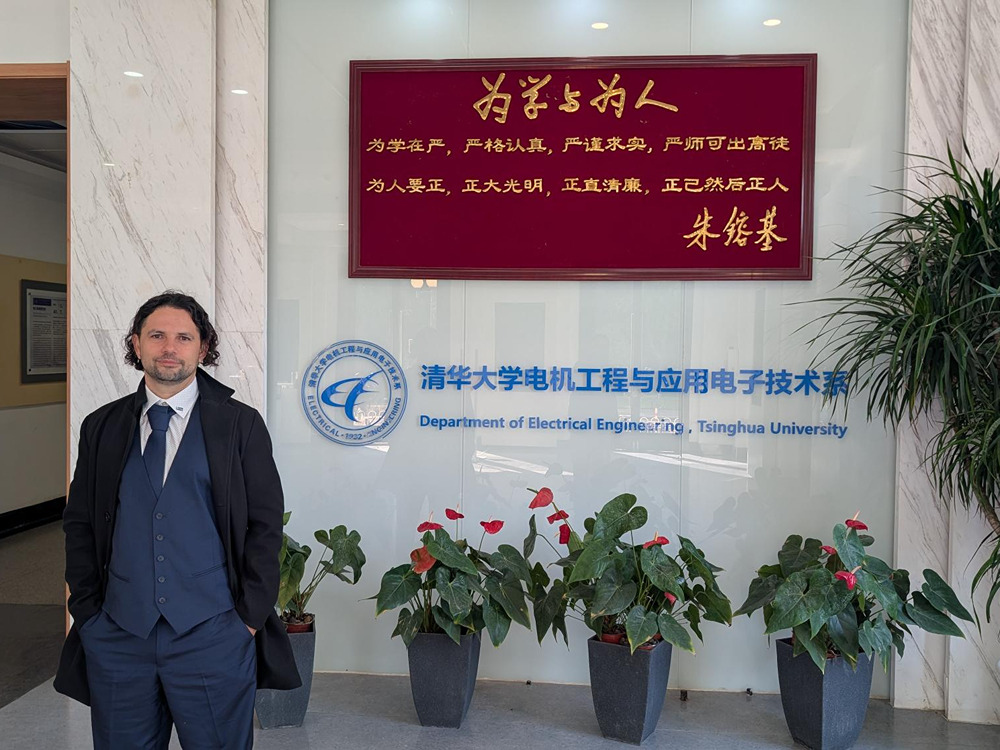 Dr. Batista de Sousa vor einem Schild mit der Aufschrift Department of Electrical Engineering, Tsinghua University, China
